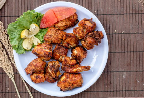 a plate of meat and vegetables on a wooden table